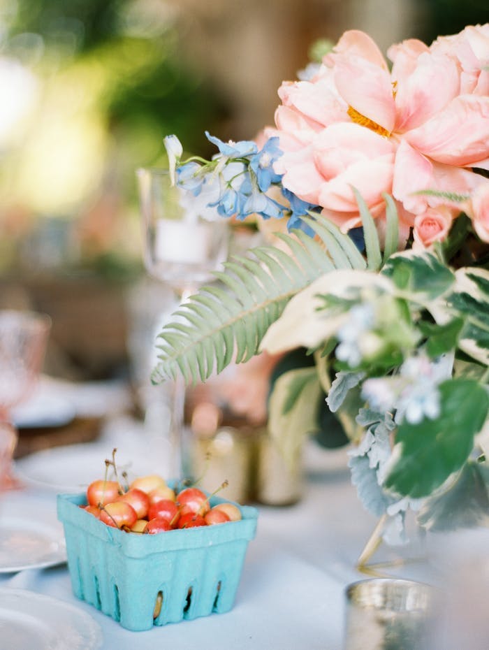 pink and green centerpieces with tomatoes in a blue carton underneath