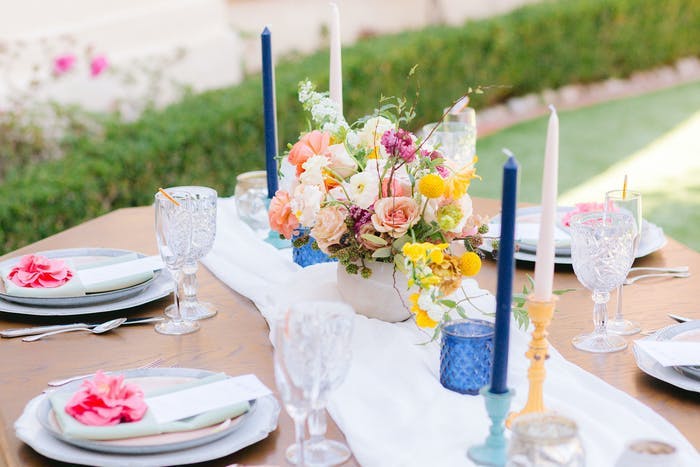 white tables scape with colorful candle holders with pillar candles