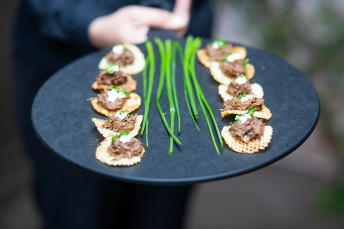 an appetizer on a slate board. Chives are down the middle