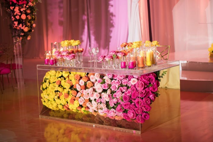 A multicolored floral covered bar with pink lighting
