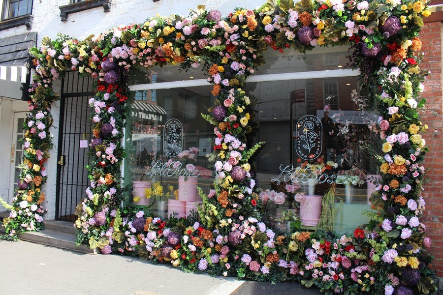 A retail level window with florals surrounding