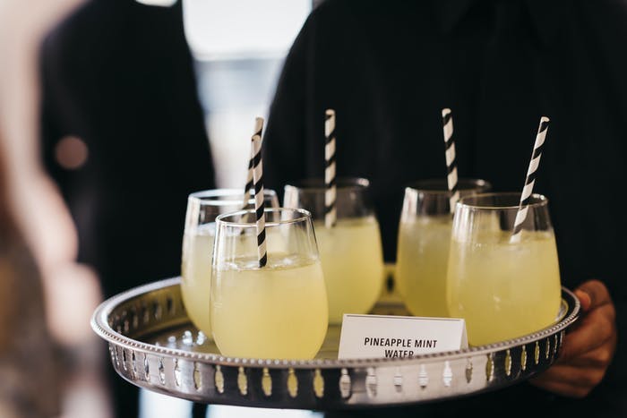Plate with pineapple juice in glasses and straws