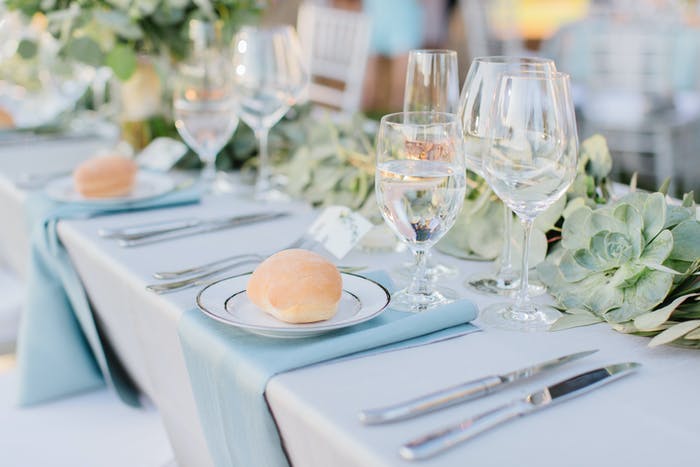 pastel blue table arrangement with a roll on each plate