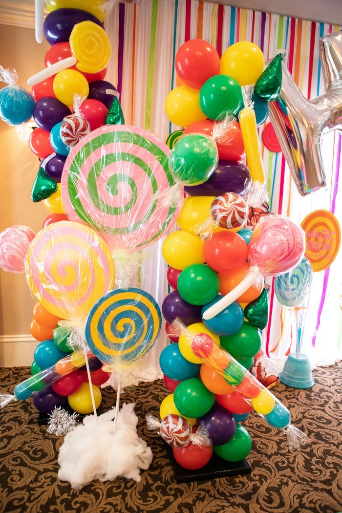 Colorful balloons intertwined with large candy elements