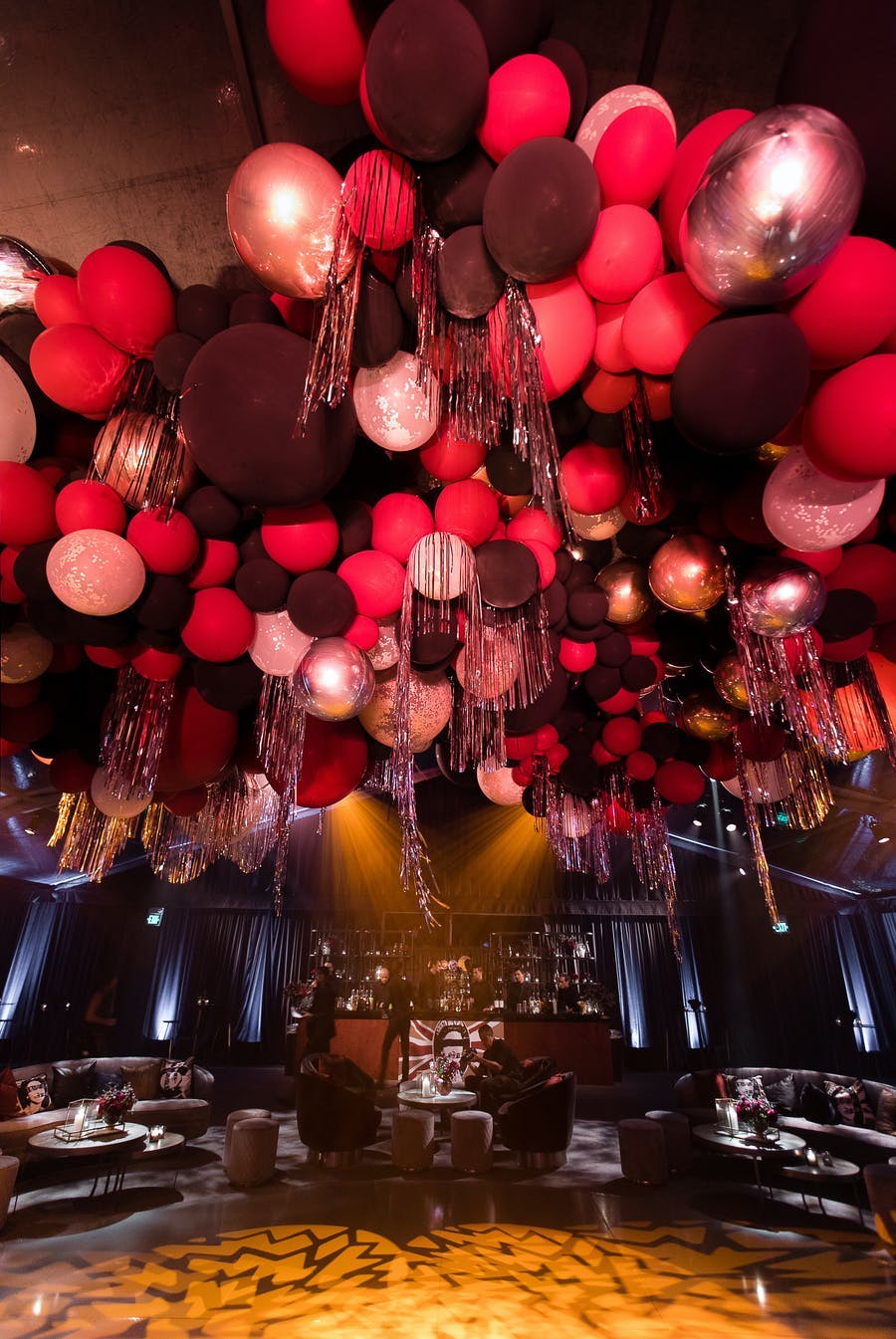 An image looking up at the ceiling with red, black and white balloons.