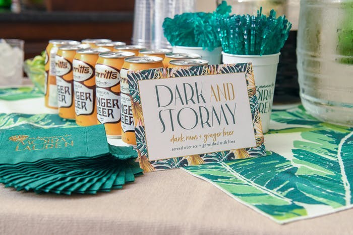 3 lines of orange soda cans lined up with teal straws and cocktail napkins