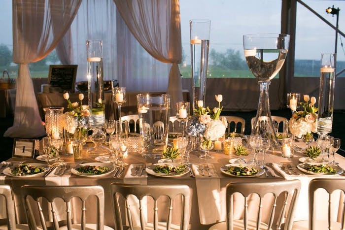 warmly lit table setting with cream drapery and lit candles