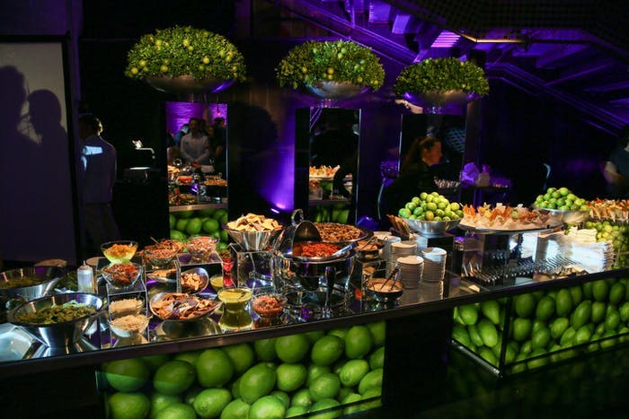 A lime centered catering station with dark and purple lighting
