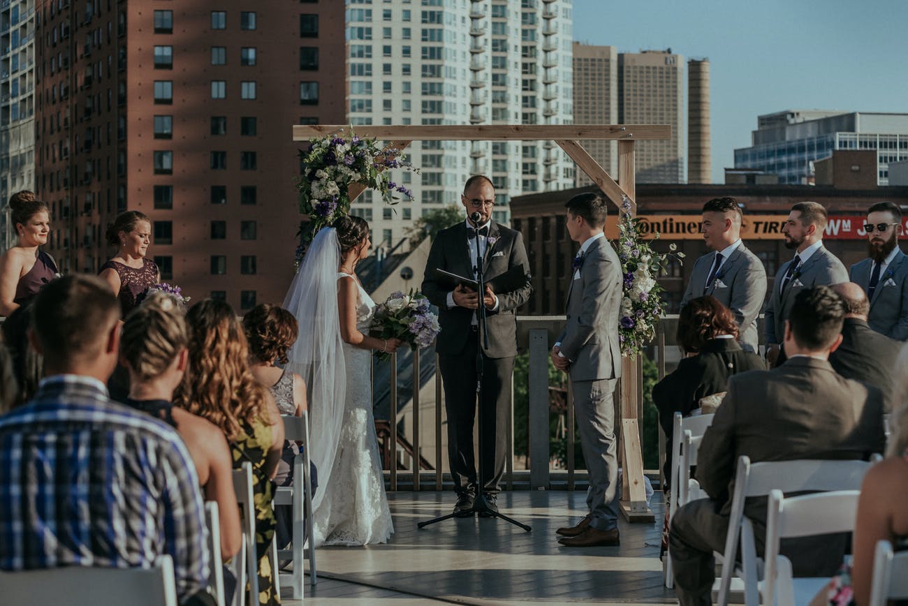 City rooftop wedding featuring rustic wedding arch.