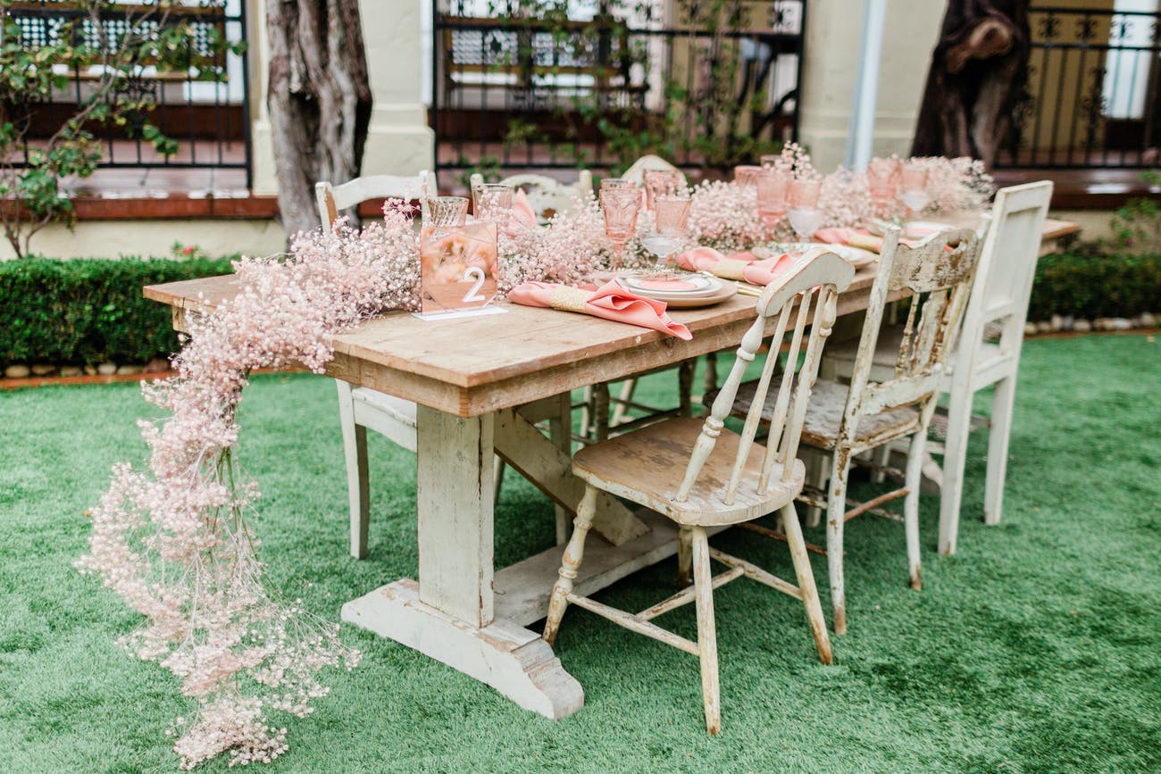 Intimate wedding reception table with pink baby's breath centerpieces.