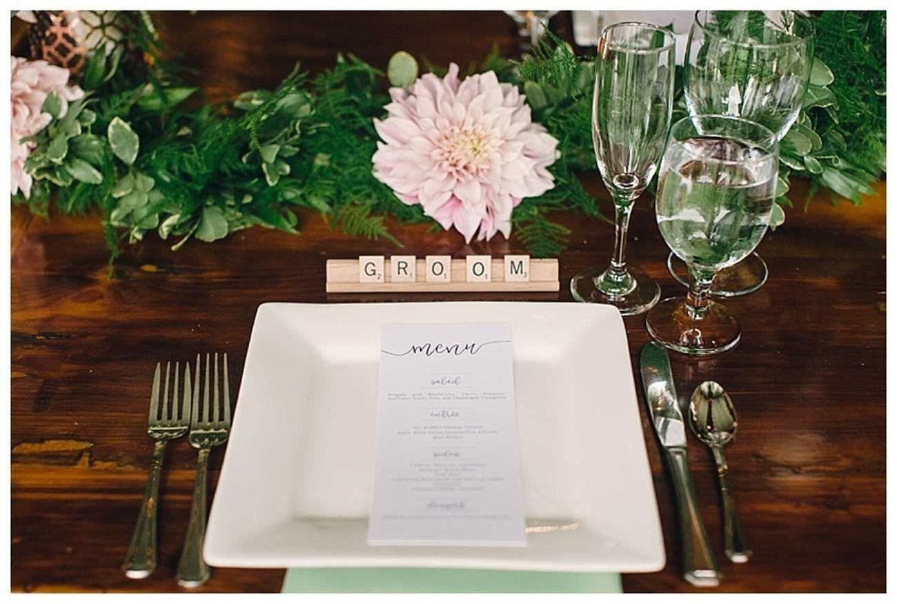 Wedding reception table with scrabble place card and pink flowers.