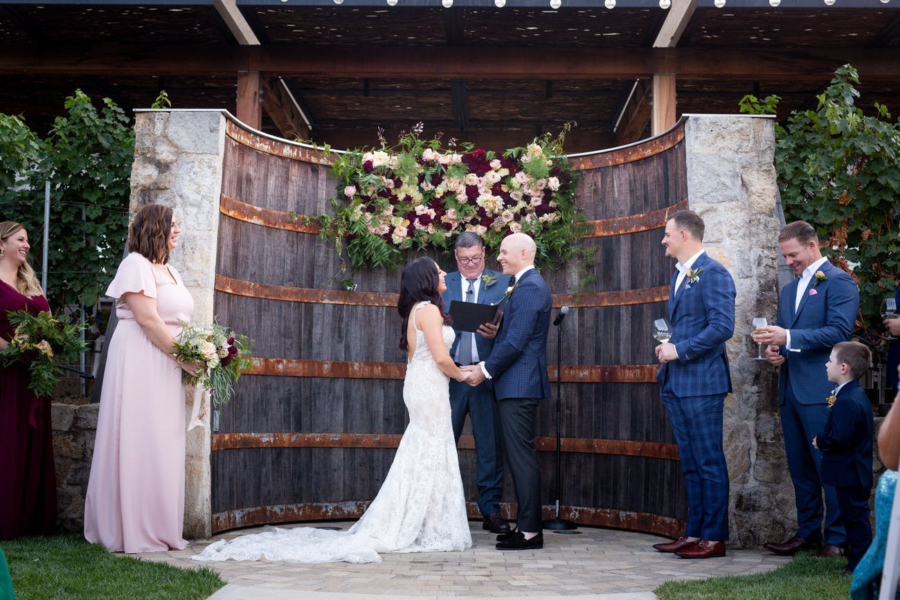 Giant wine barrel wedding ceremony backdrop for a rustic wedding | PartySlate