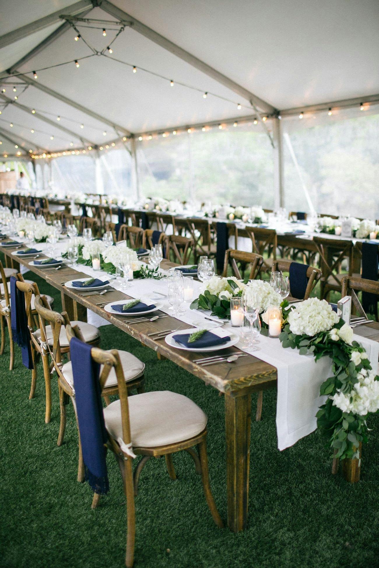 Wedding reception tent and tables with blue chair décor.