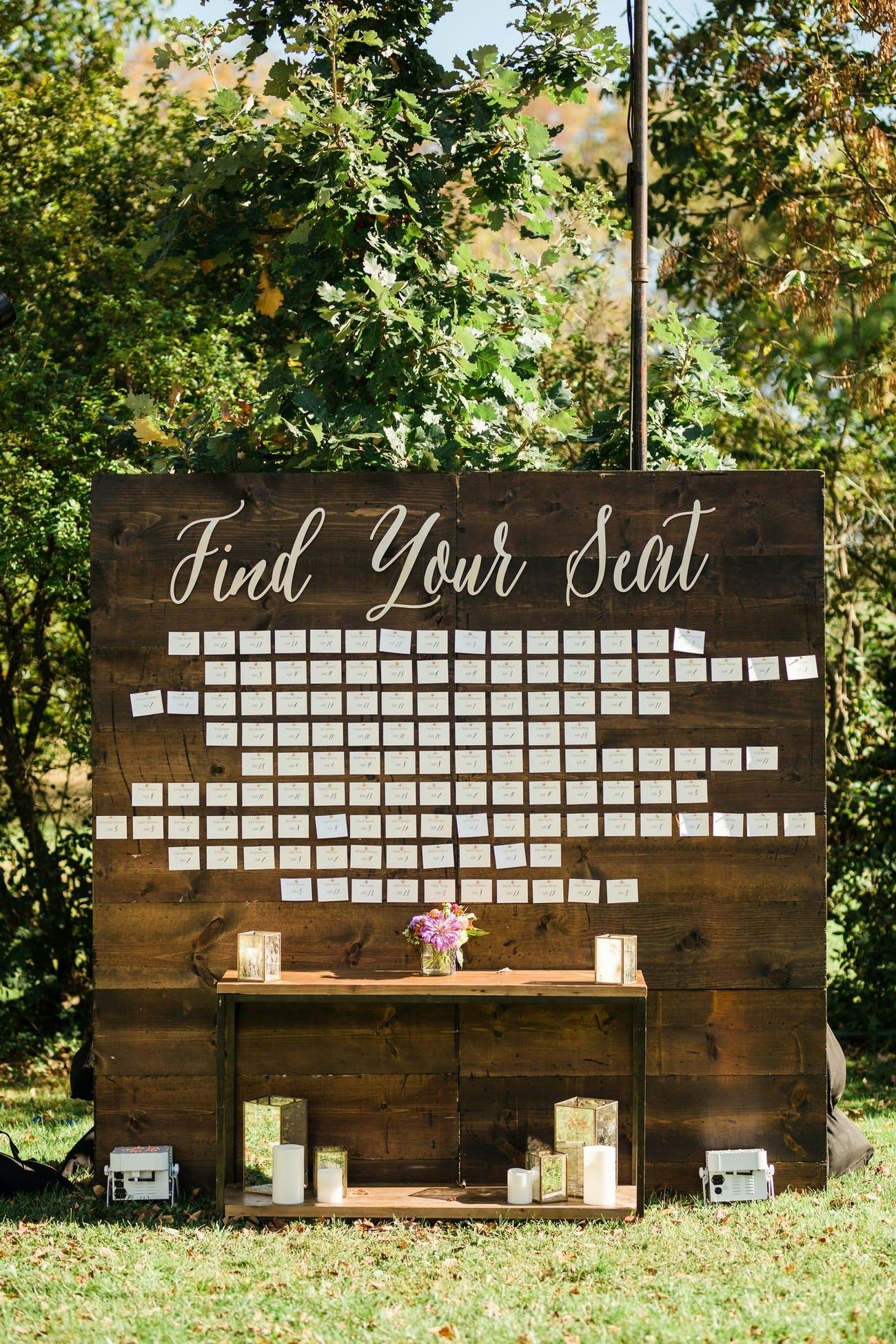Wedding seating chart against rustic wooden wall backdrop | PartySlate