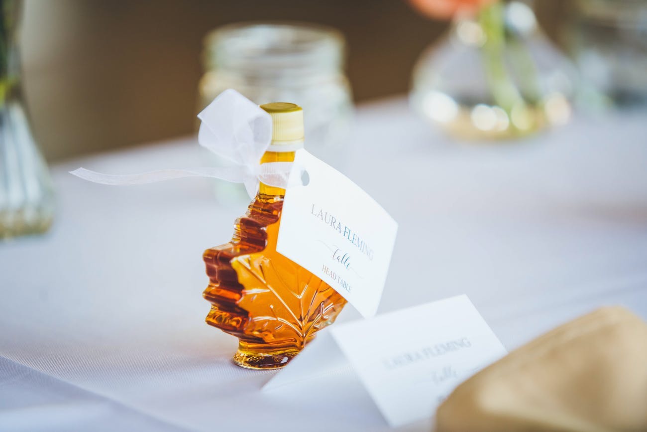 Wedding party favor of mini leaf-shaped maple syrup bottles.