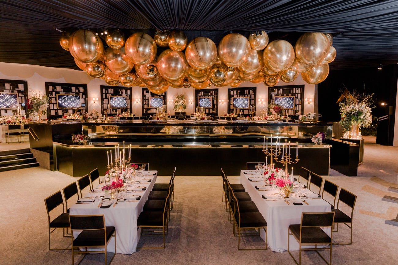 Lavish gold balloon ceiling installation | PartySlate