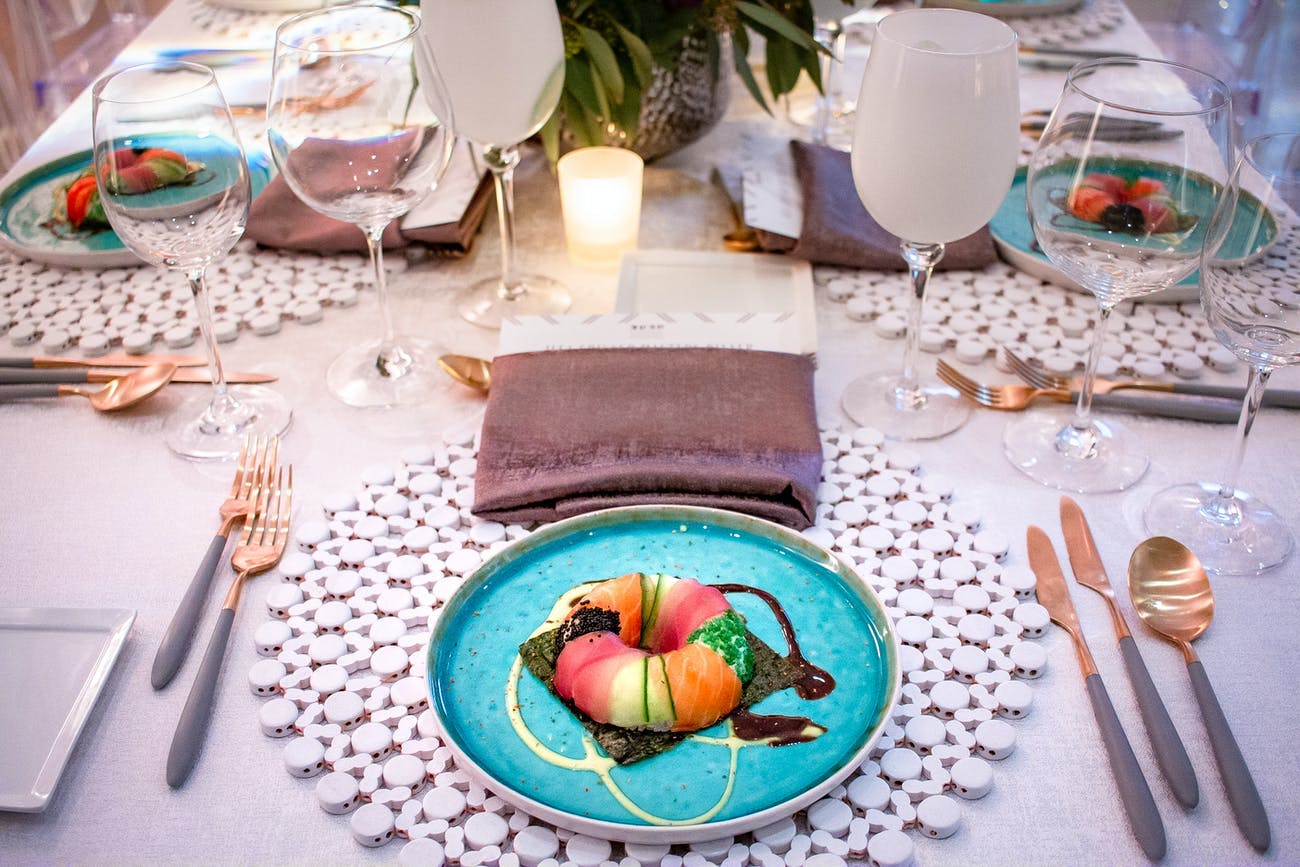 Corporate dinner party with colorful dishware and artistic food presentations.