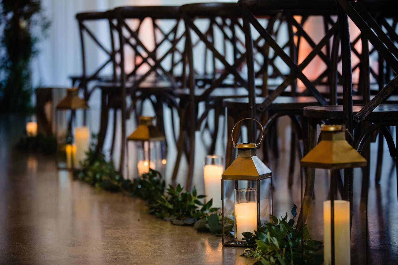 Wedding ceremony aisle with rustic lantern décor.