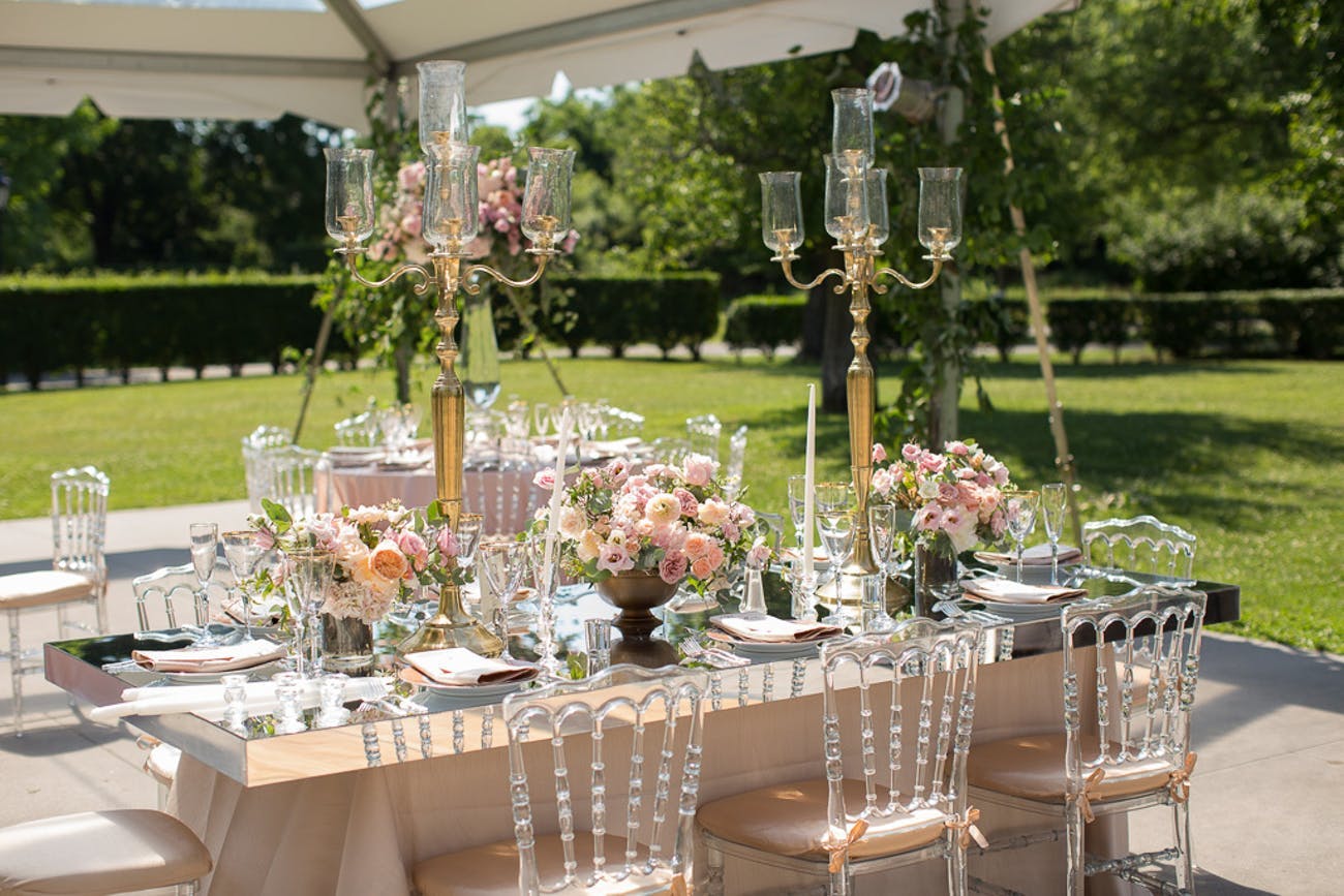 This charming outdoor wedding has us mesmerized with towering gold candelabras and delicate pink blooms
