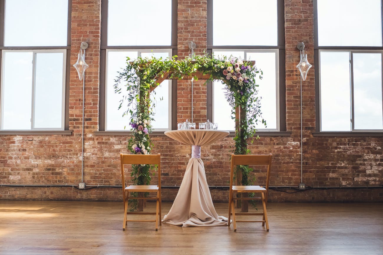Modern and rustic wedding arch in industrial loft space.