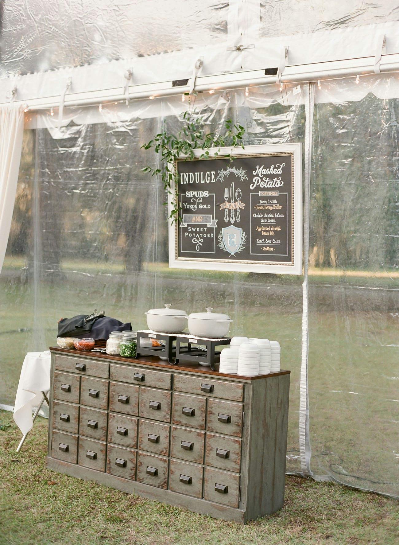 Rustic wedding catering station with vintage dresser.