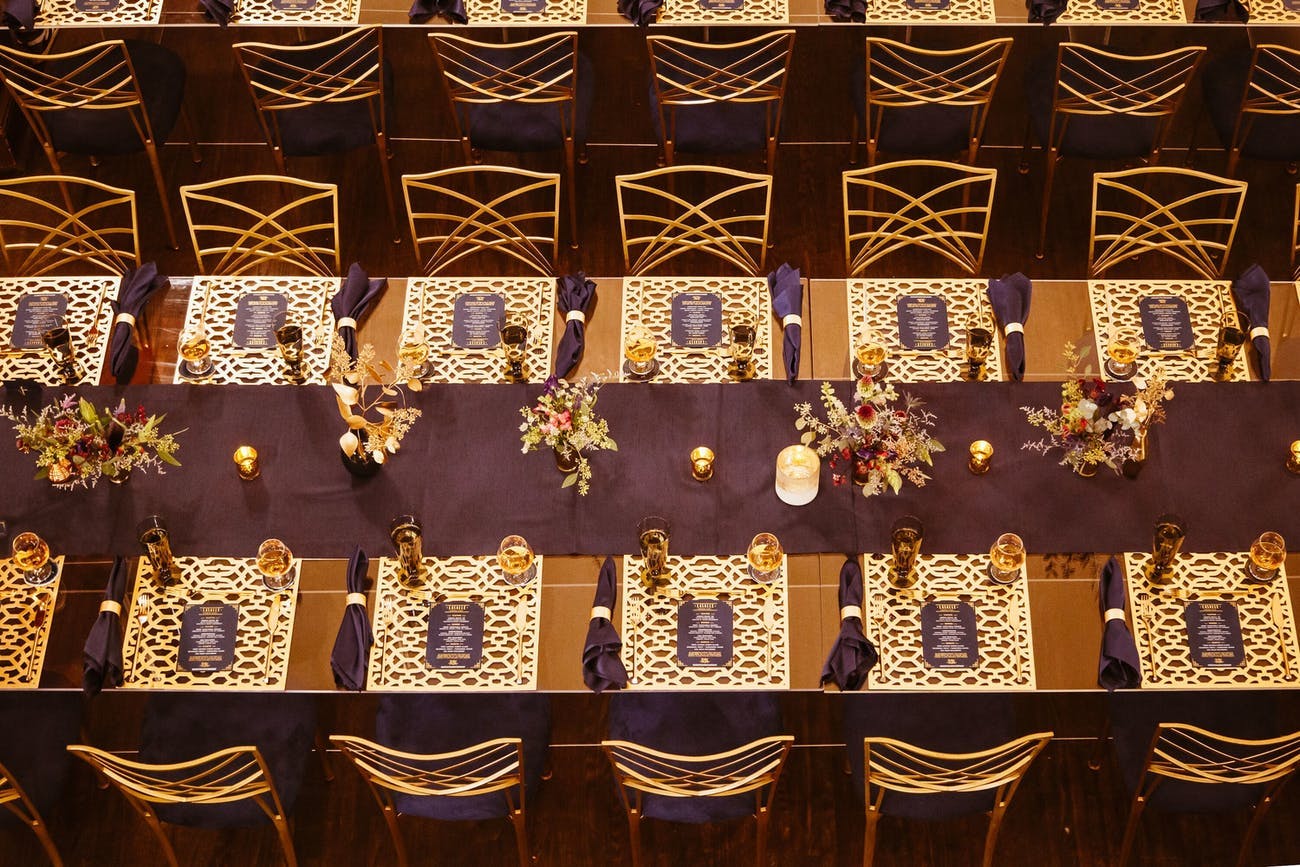 Corporate dinner party with purple and gold table décor | PartySlate