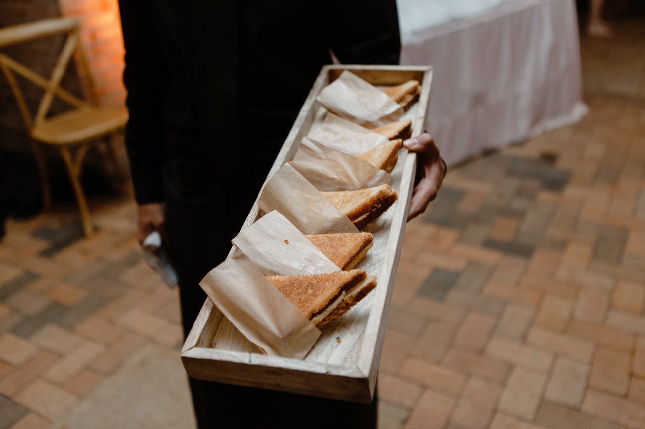 Wedding passed plates of individually-wrapped grilled cheese.