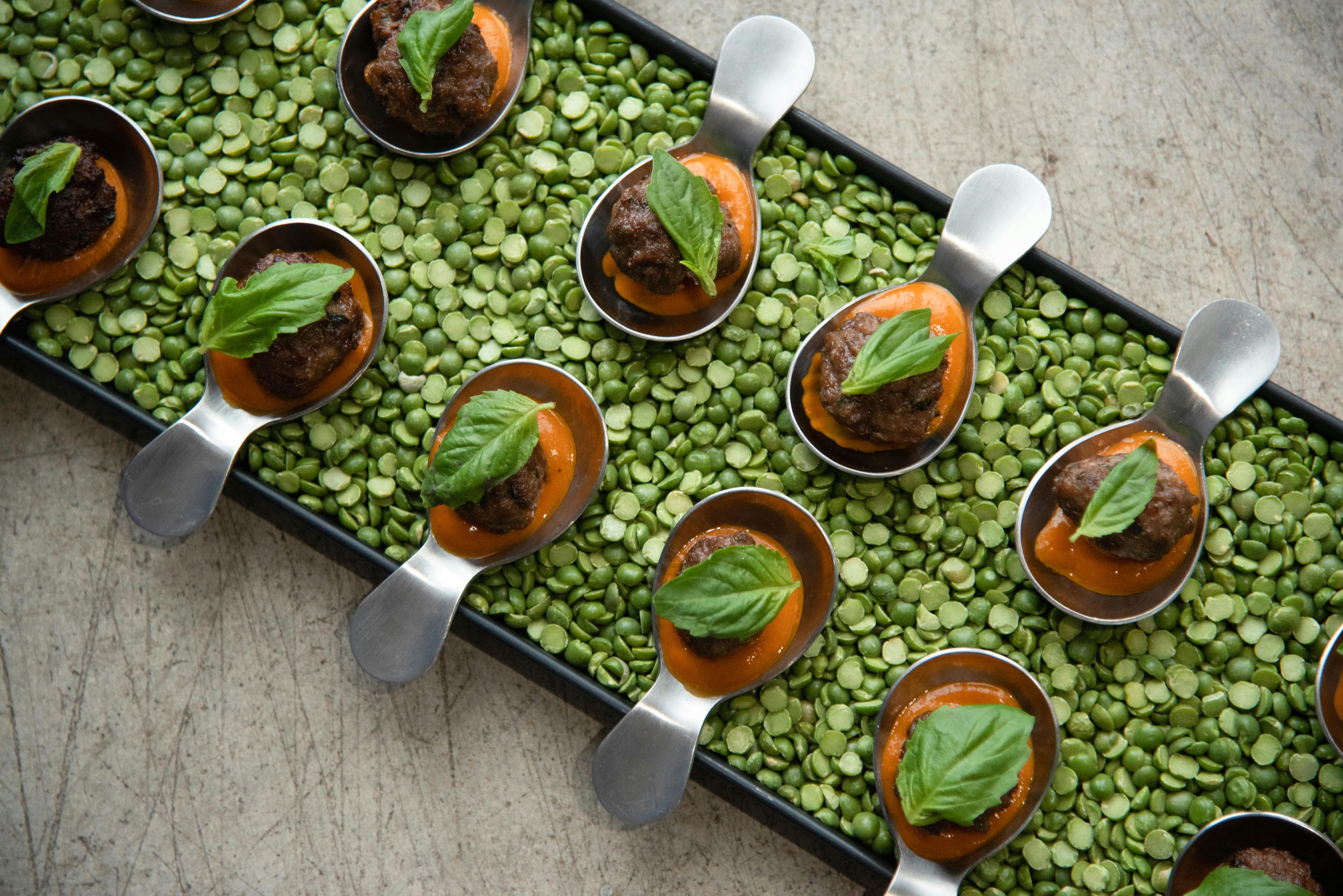 Corporate dinner party with passed appetizer trays filled with dried green peas.