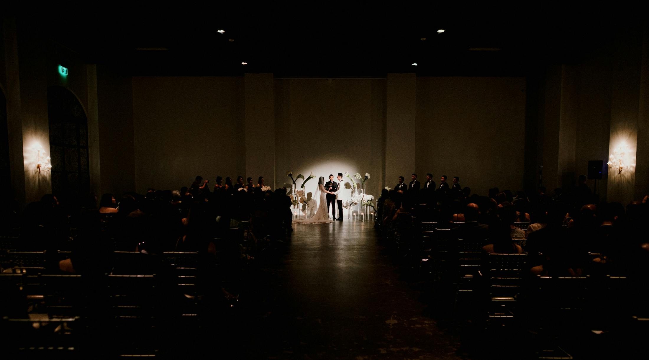 Dimmed Wedding Ceremony With Spotlight Shining on Couple | PartySlate