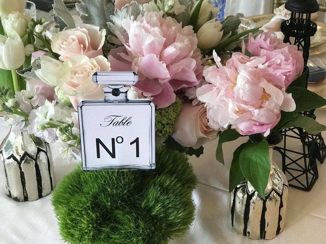 Table Number Written on a Perfume Bottle with Flowers