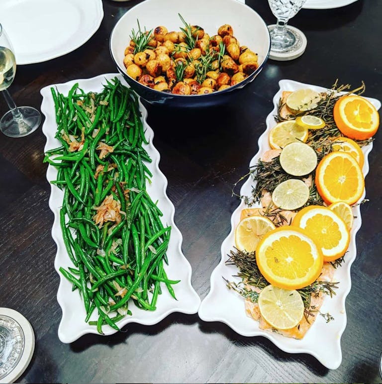 Catered salmon with lemons, green beans, and potatoes.