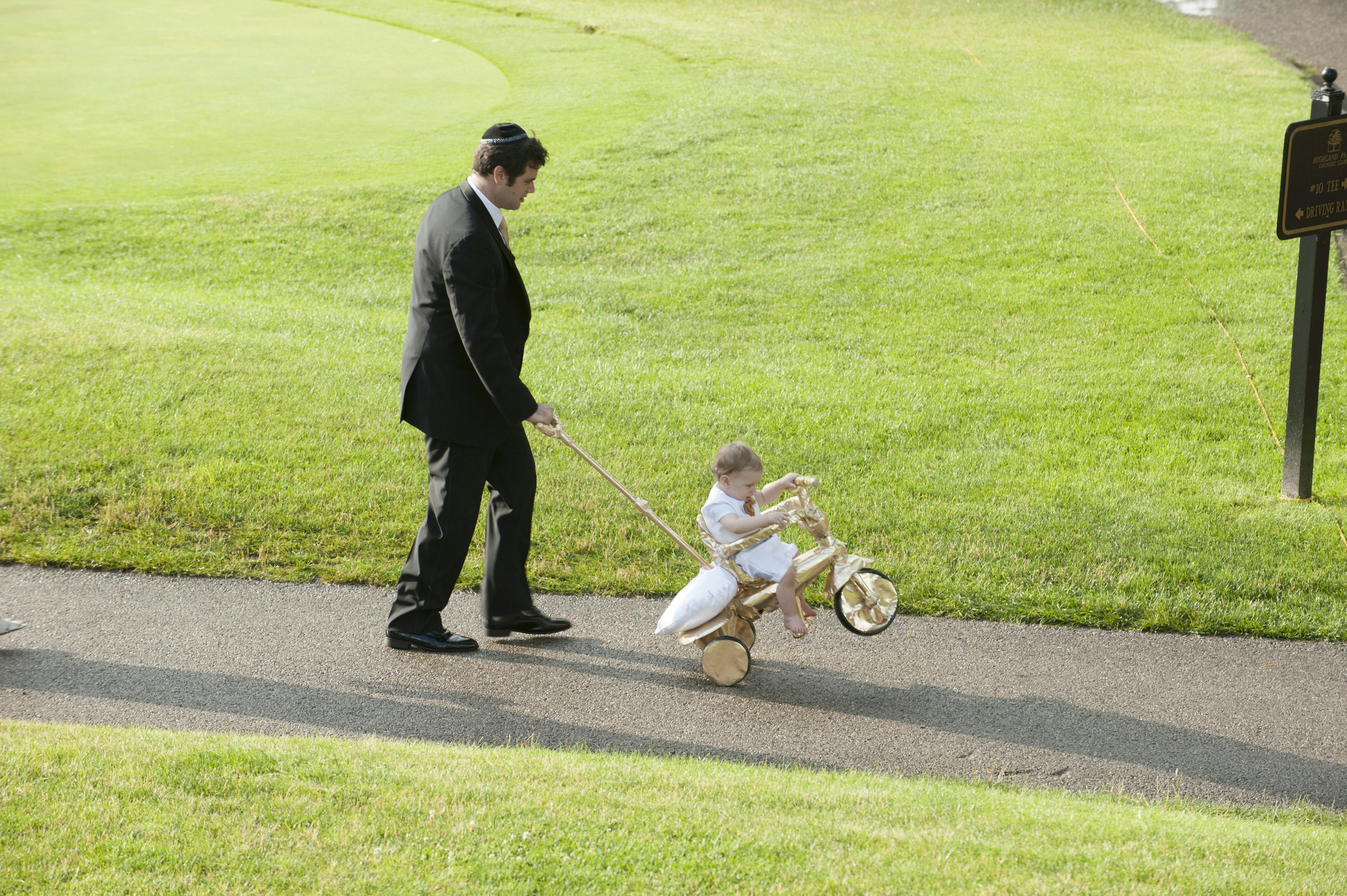 Traditional Jewish Wedding Celebration Where Father Pushes Kid on Bicycle Down Wedding Aisle | PartySlate