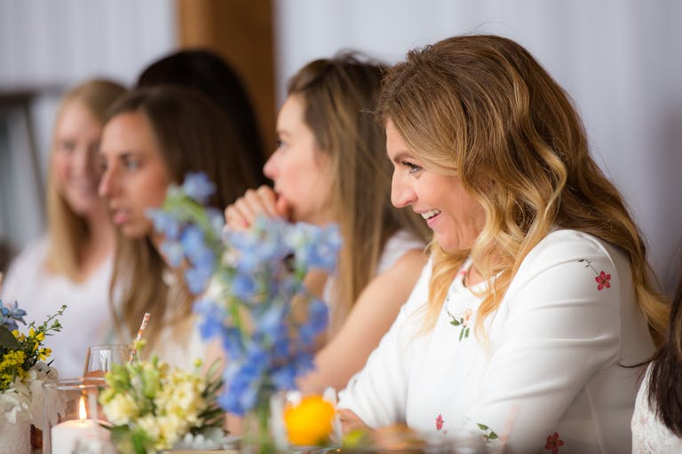 Build Your Own Bouquet Baby Shower women talking across a floral table | PartySlate