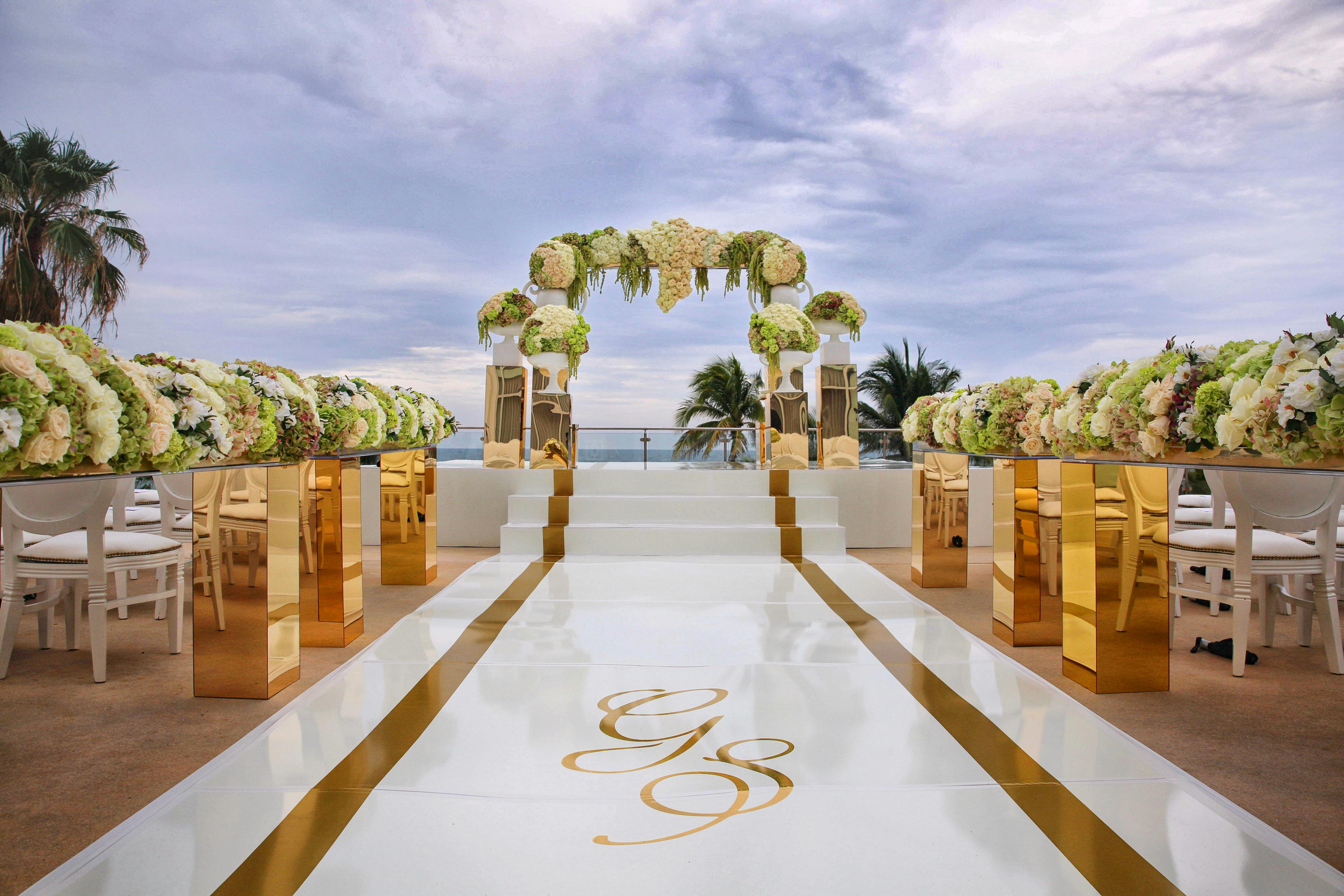 Oceanfront wedding with white, gold and floral decor | PartySlate