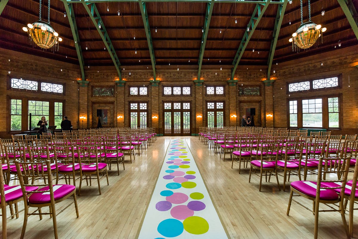 Creative wedding with fuchsia chairs and colorful aisle décor | PartySlate