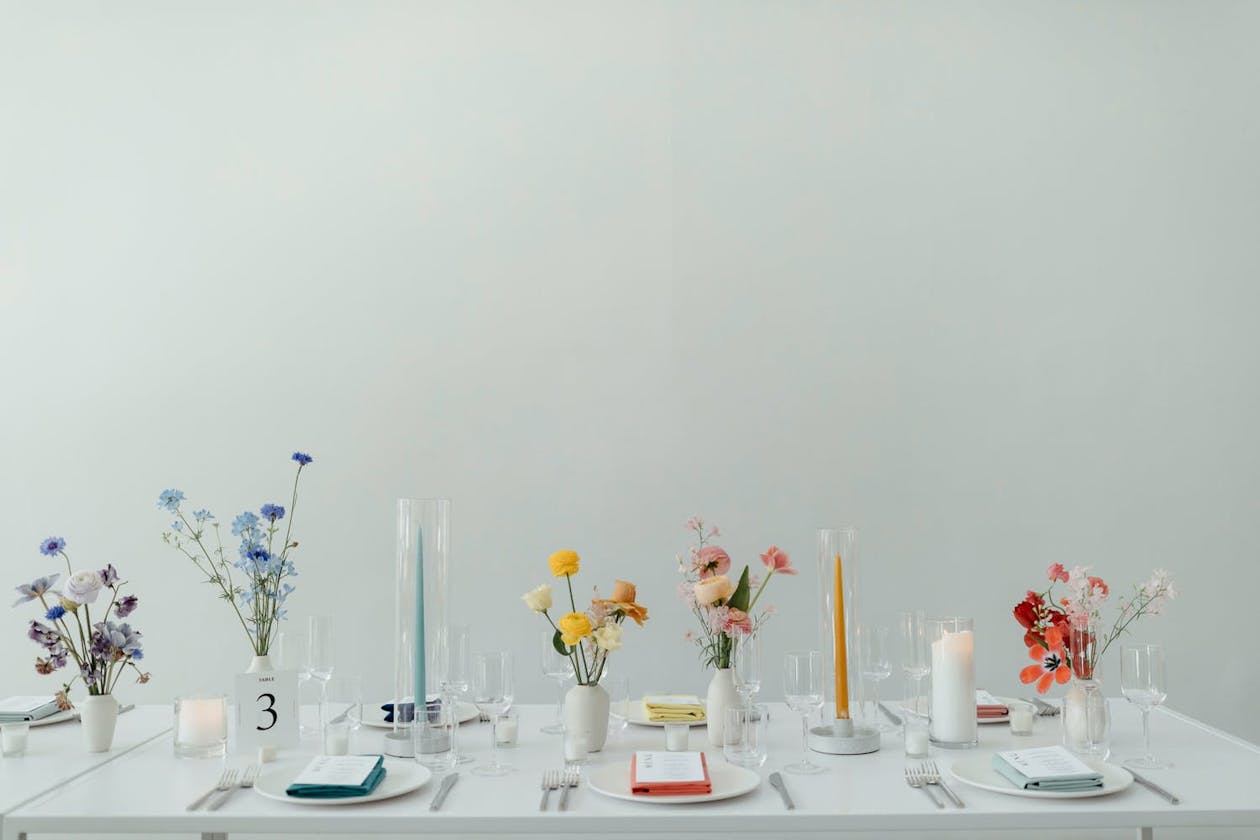 Rainbow inspired floral arrangement on a sleek white table | PartySlate