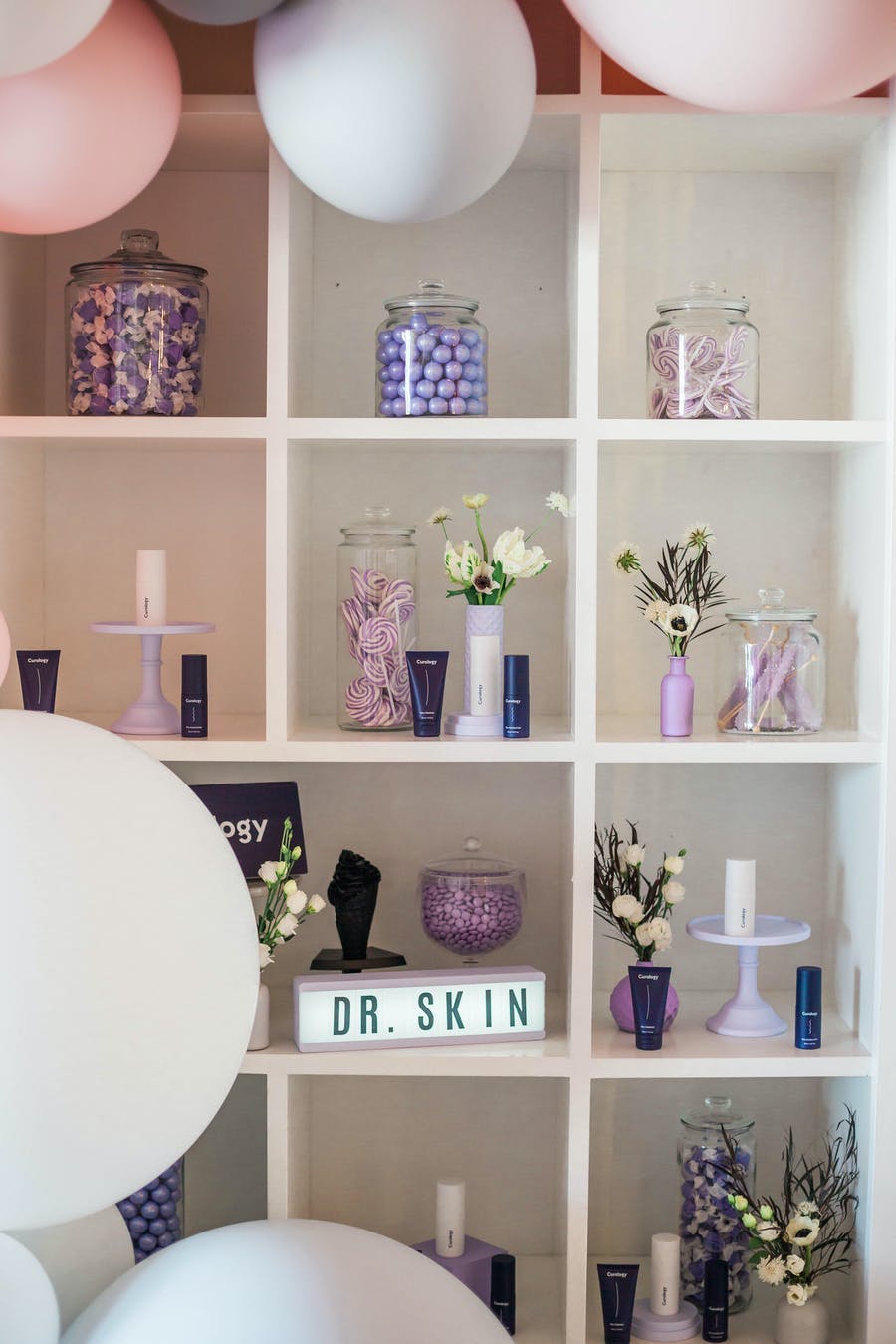 Pink and purple shelving with jars and flowers | PartySlate