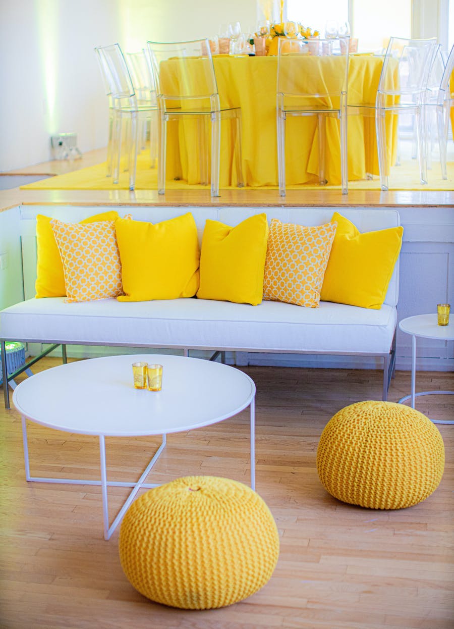 White lounge area and seating tables with yellow accents | PartySlate