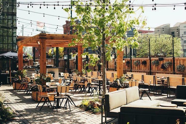 A courtyard rooftop in Chicago with wooden seating and accents with string lights | PartySlate