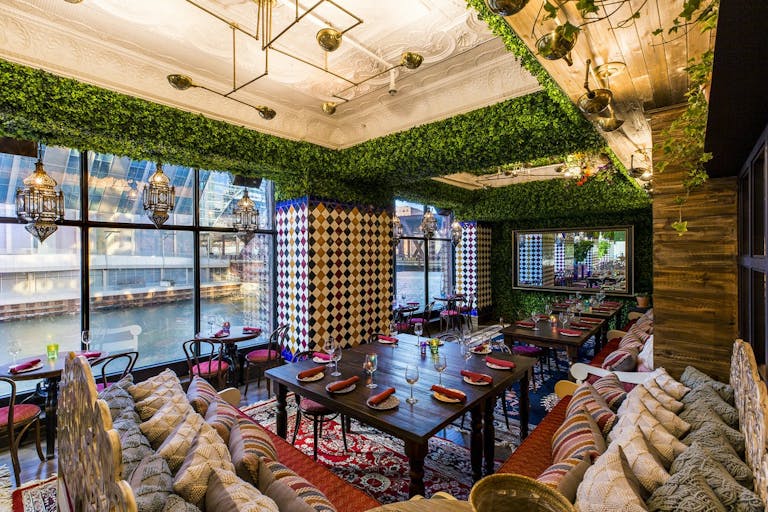 Large dinner tables with patterns on the walls and a view of the Chicago river, an event space for your sweet sixteen | PartySlate