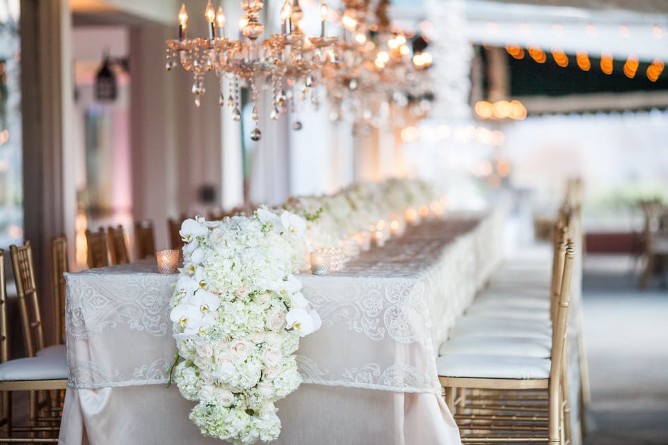 Wedding Reception Table with White Linen, Gold Chairs, and White Hydrangea Wedding Centerpieces