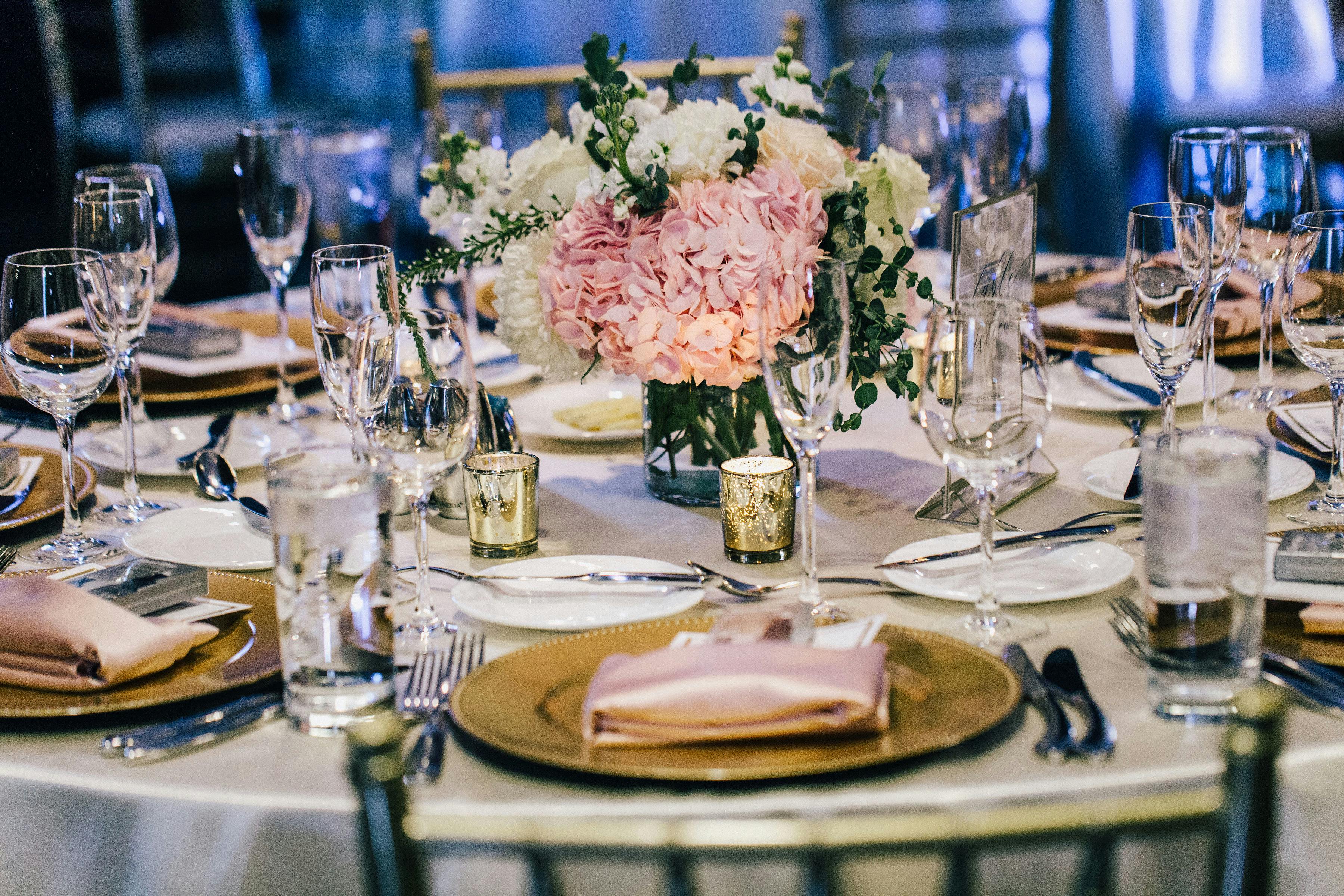 Wedding Table with Pink Hydrangea Wedding Centerpieces, Gold Plates, and Pale-Pink Napkins