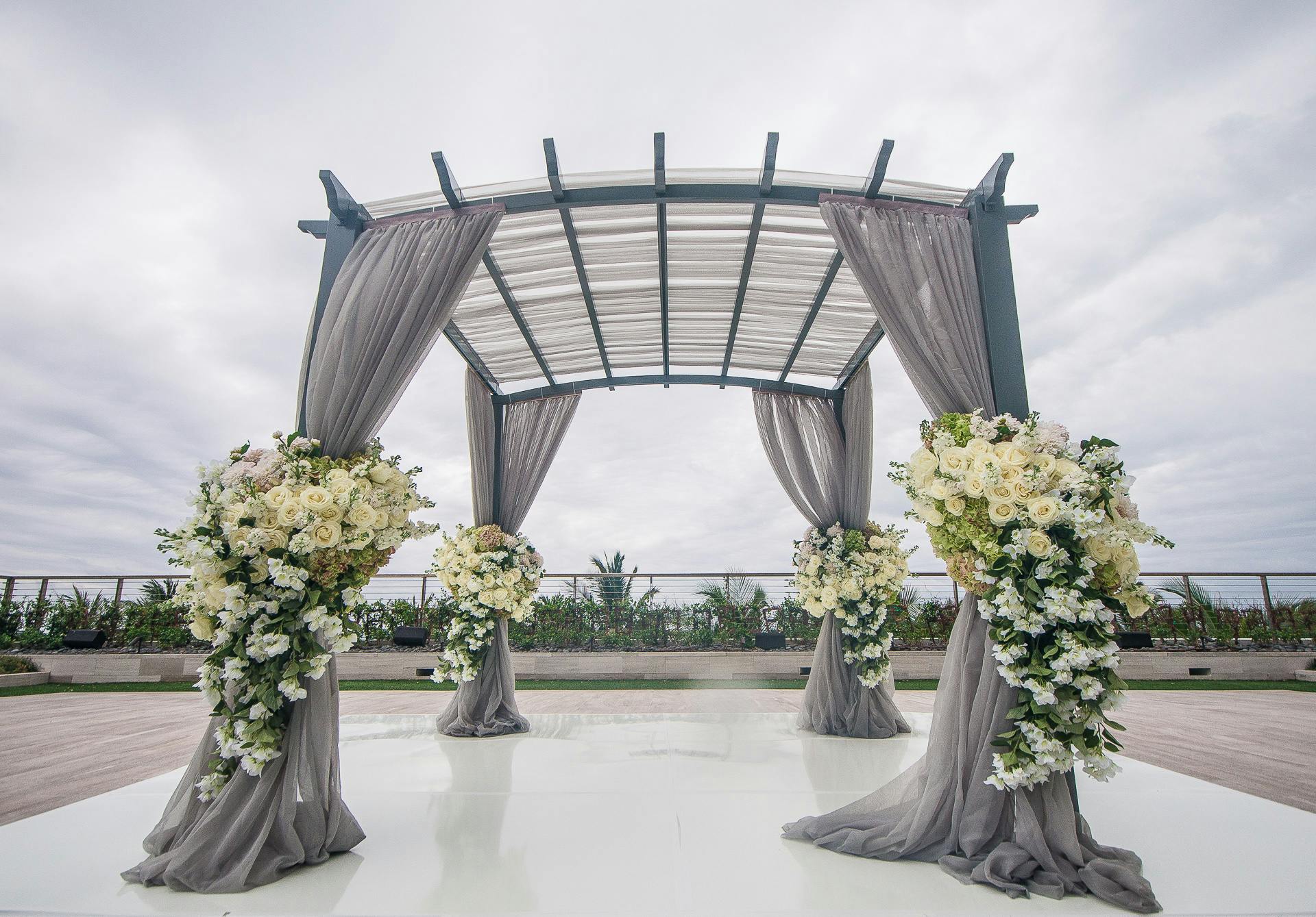 Modern Wedding Arch with Ethereal Gray Drapery and Florals in White and Green Spring Wedding Colors