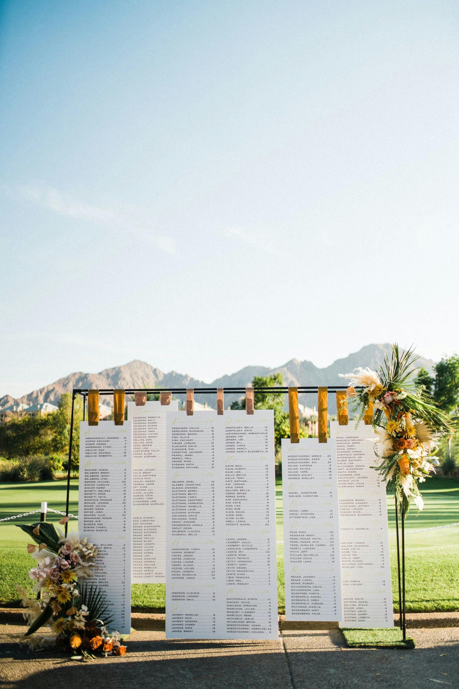 Oversized wooden clips holding up scrolls of seating char | PartySlate