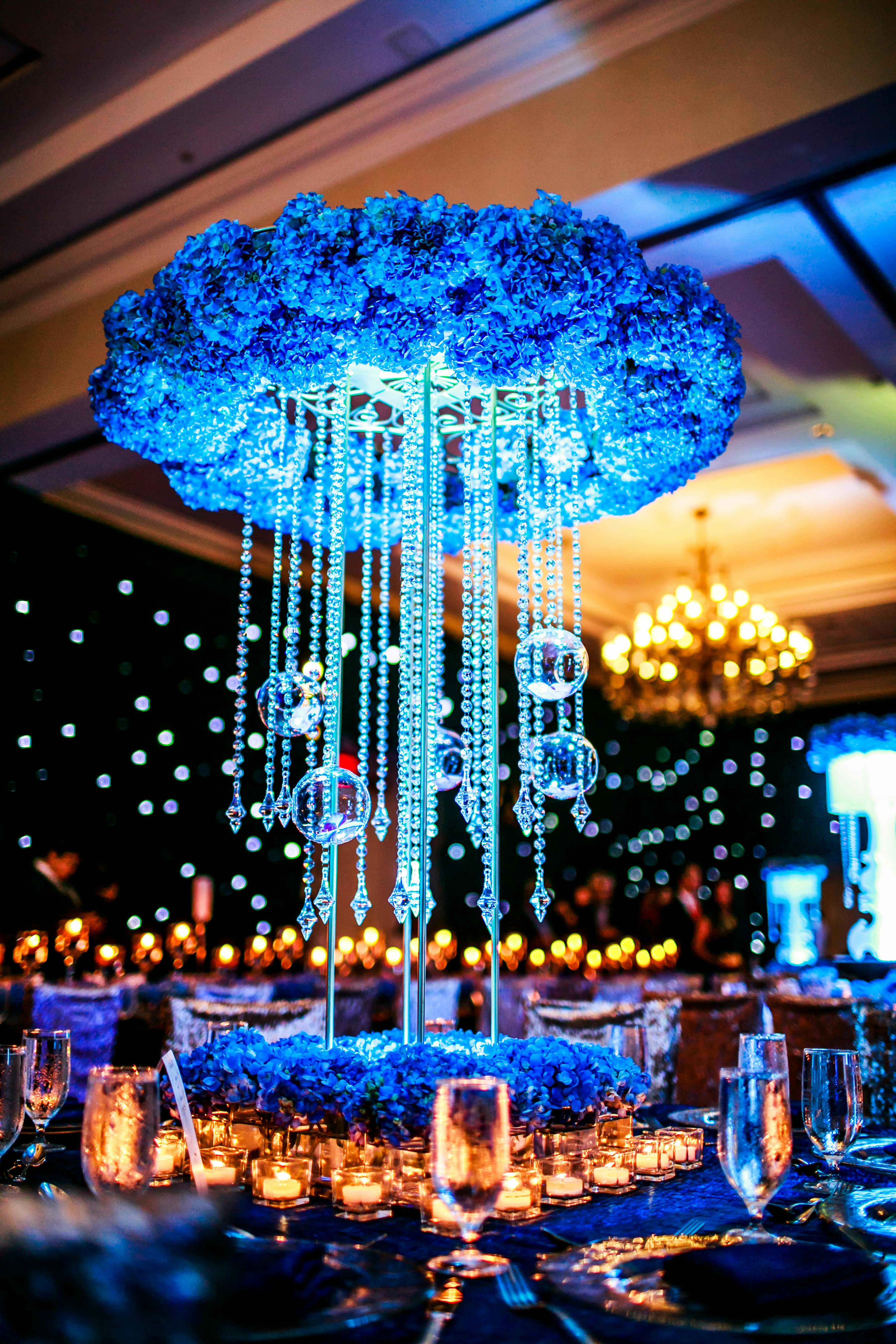 Towering Wedding Centerpiece with Wreath of Blue Hydrangeas and Suspended Crystals and Glass Globes