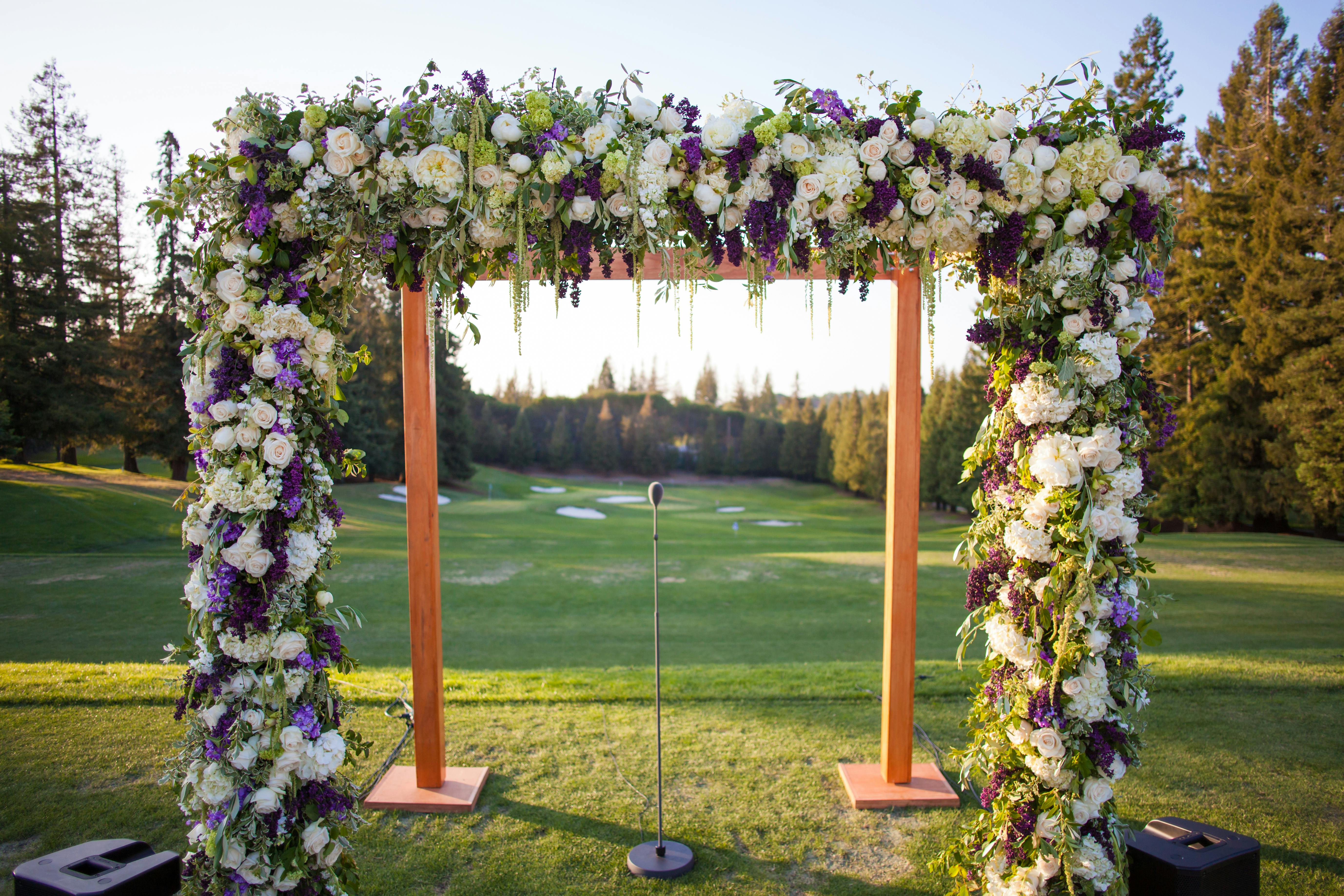 Wooden Wedding Arch with Florals in White, Green, and Purple Spring Wedding Colors