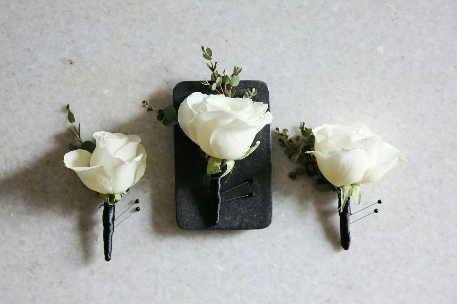 White Rose Boutonnières with Stems Wound in Black Ribbon | PartySlate