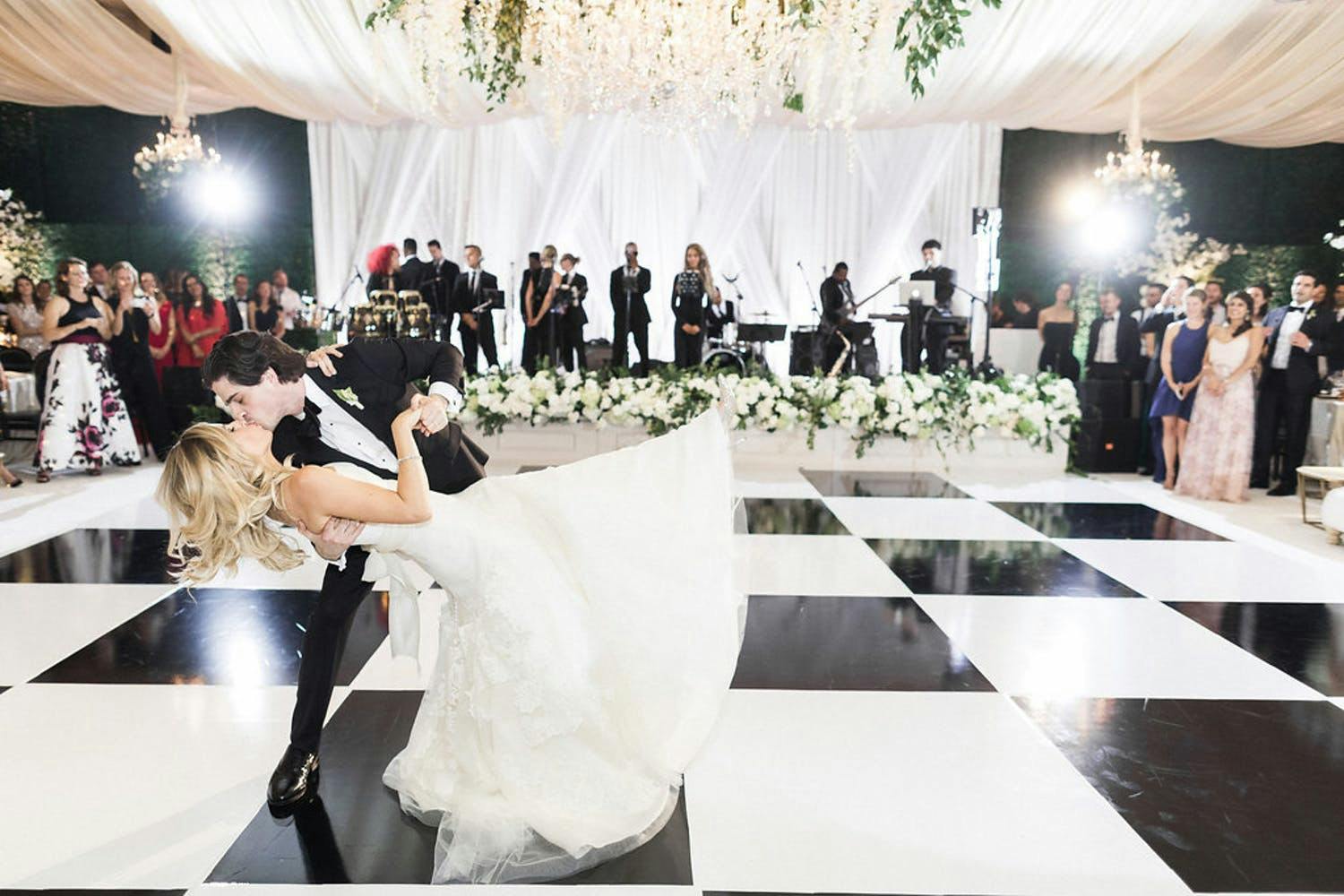 Couple Kisses Mid Dance on Black and White Checkered Dance Floor | PartySlate