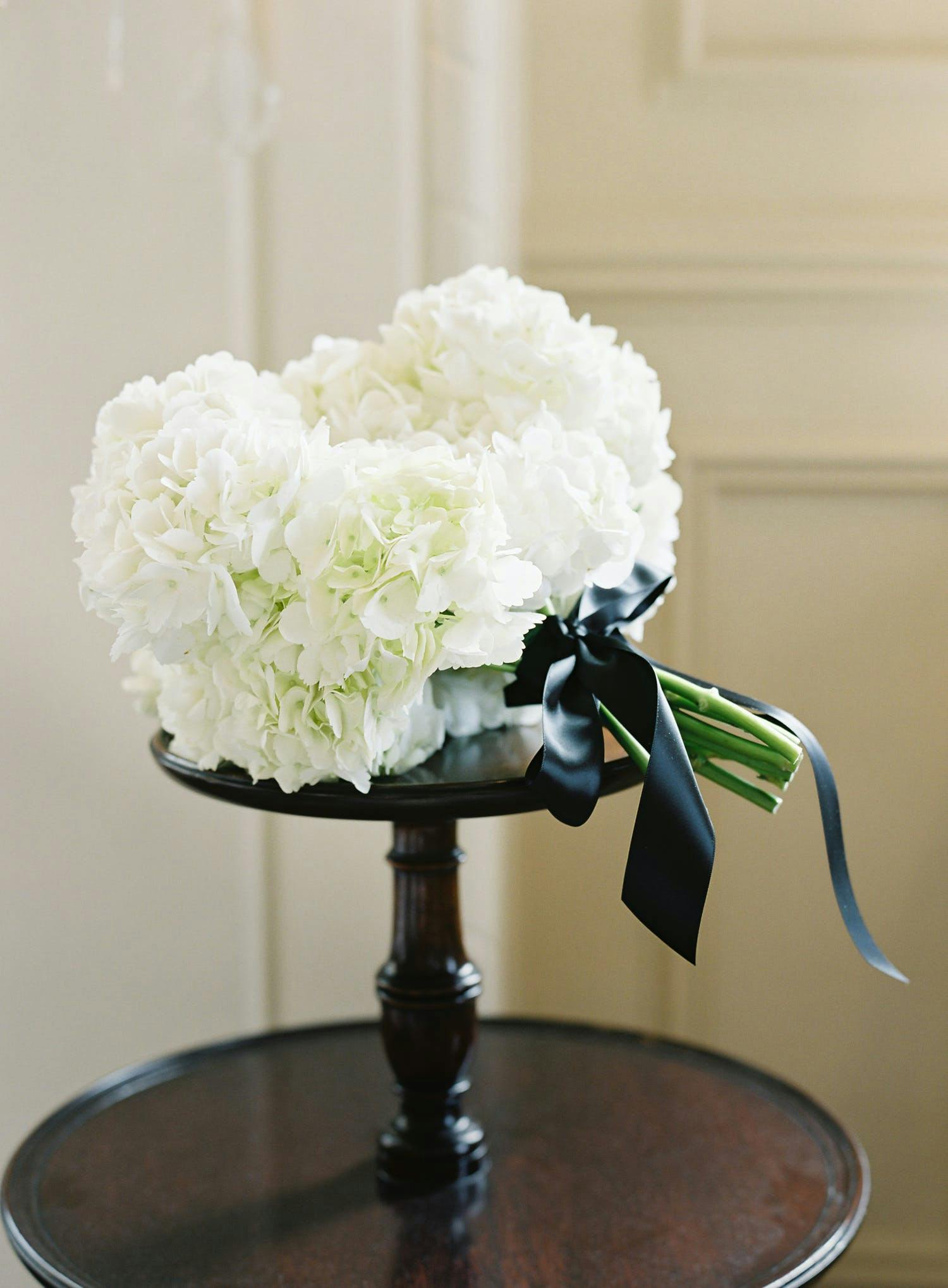 White Hydrangea Wedding Bouquet With Black Bow | PartySlate