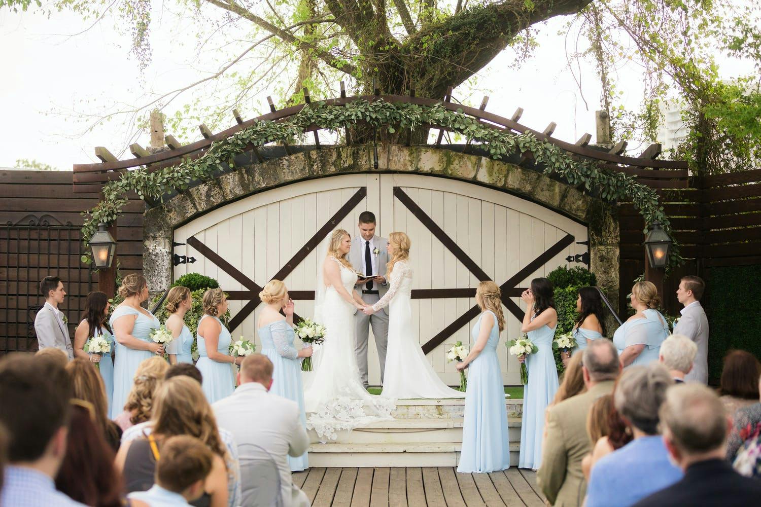Two Brides Exchange Vows at Hughes Manor in Houston, Texas With Rustic Barn Doors in Backdrop | PartySlate